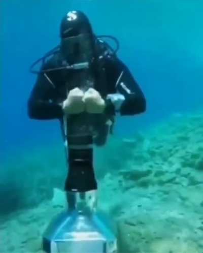 Diver bends air under-water to open cap ?