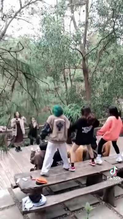 A group of young people dancing on a table while traveling to make a TikTok video