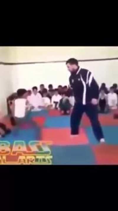 Teacher teaches kids how to do Karate
