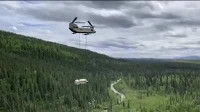 An Alaska Army National Guard CH-47 Chinook helicopter airlifting the "Magic Bus” out of the woods just north of Denali National Park and Preserve in Alaska