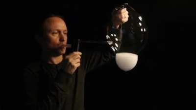 Guy makes an upside down smoke burning tornado in a bubble
