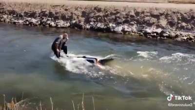 Guy floats down a creek on the roof of an SUV that he apparently just purchased a week prior
