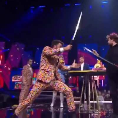 HMC a lady holds a flamethrower in the wrong direction at a Belgian TV show
