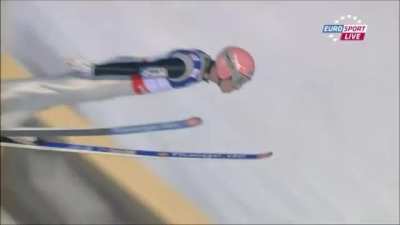 Austrian ski jumper Manuel Fettner sticks his landing despite losing his right ski in the process. As he only fell after crossing the "fall line" the jump counted and would later on be a major contributor to the Austrian team winning the gold medal in the