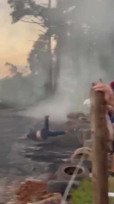 Guy stands out of a moving car to impress the crowd ends up falling.