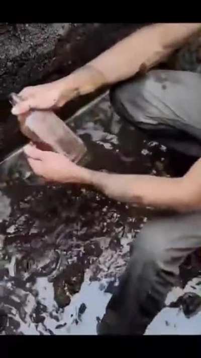 Guy finds a 100-year-old bottle digging in the mud