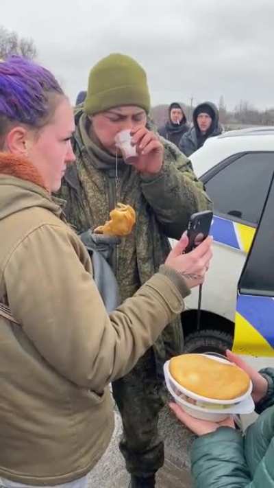 Ukrainians provide hot food and tea to a Russian soldier who voluntarily laid down his arms