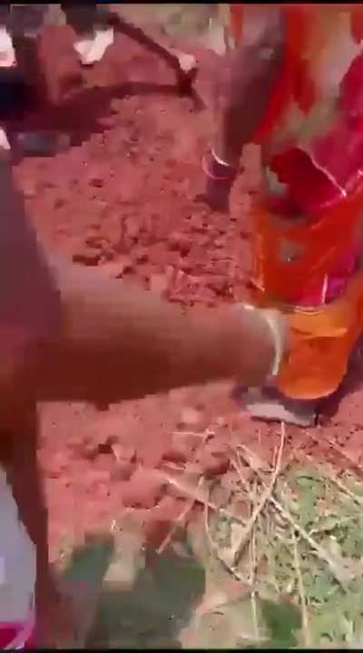 Women being pulled up after they were buried alive over property dispute in India