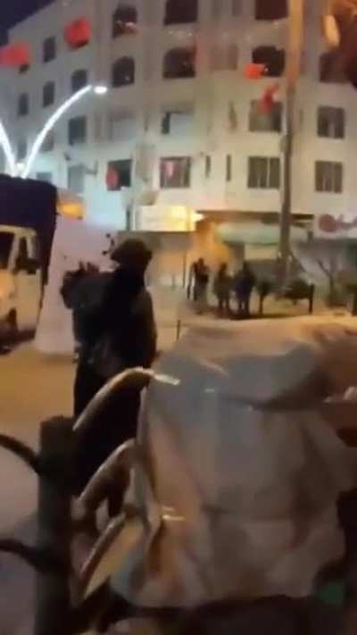 An Israel Defense Force soldier protecting a Palestinian woman