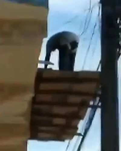 This bricklayer tied the safety cable to the electrical wire of the street lamp.