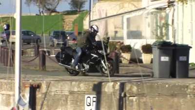 Riding a motorcycle next to the docks
