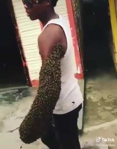 Guy relocates hive by carrying queen in his hand