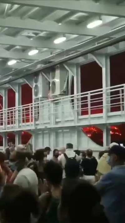 Citizens escape above a commercial ship as the huge fires , that have blocked all roads, close on them. Video taken from Evia Greece.