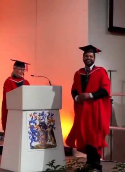 Daughter cheers for her dad at his graduation.?