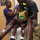 Dad gets (pretend) vaccinated first so daughter is less scared by needles.