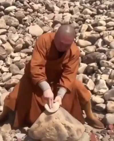Monk breaks stones with his fingers