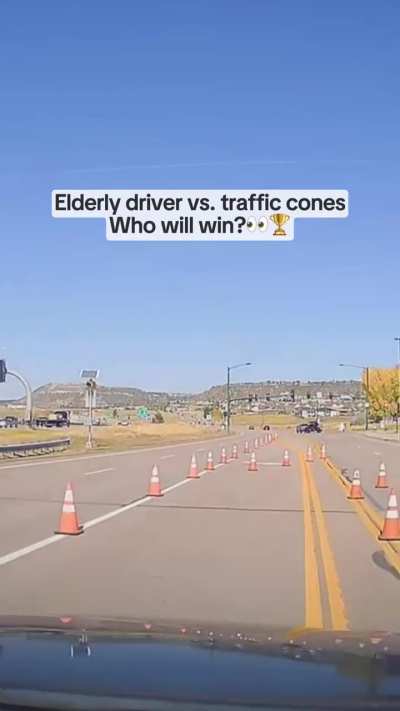 A bad driver struggles with traffic cones, and ends up pulling up to the traffic lights in the opposite lane of traffic