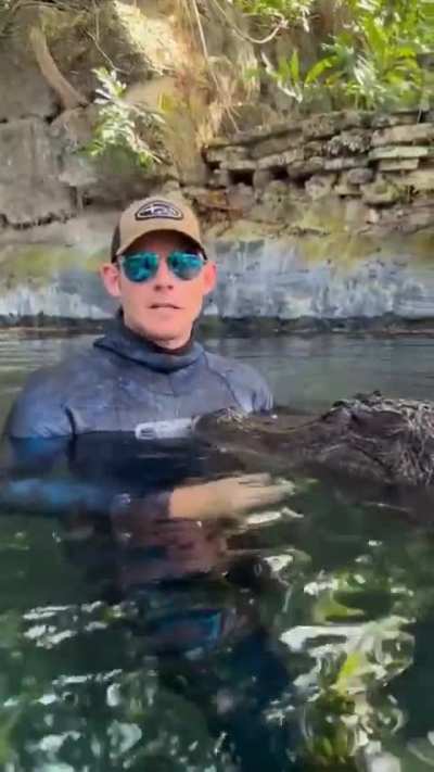 A human interacts with a wild and deadly animal