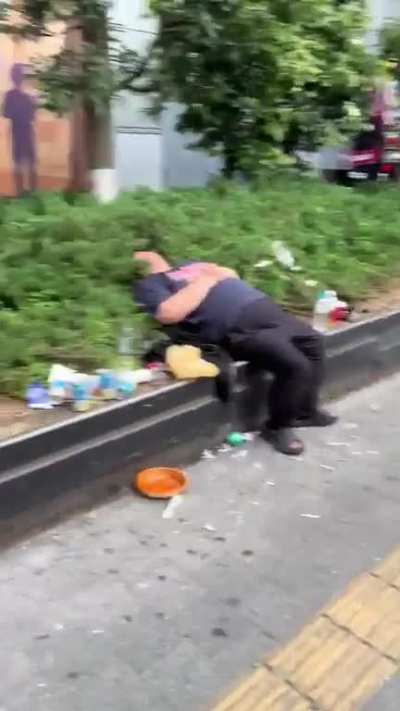 Japanese guy laughing at his friend joking about guys passed out on the street