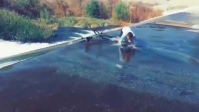 An idiot trying to cross a river with a bike