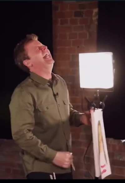 Guy laughs at his mates painting ?