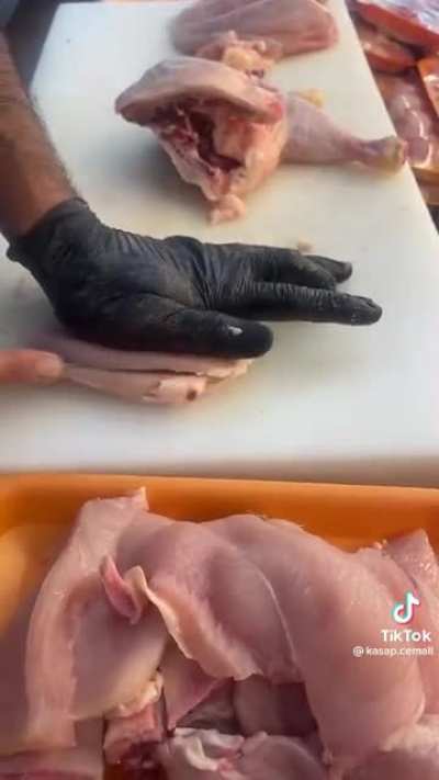 Cutting chicken into pieces.