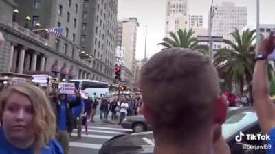 Vegan protest blocks road, while a pregnant woman is in one of the cars