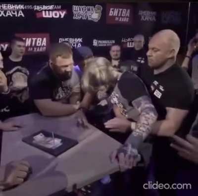 Watch the guy on the right win a prize after challenging the slap champ who's twice his size