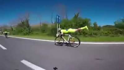 This cyclist unclips from his pedals, lies down on the seat and stretches out to achieve ultimate aerodynamic efficiency and overtake others.