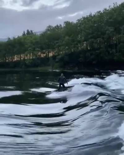 Surfing a river break in Norway