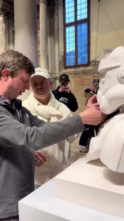 Artist Daniel Arsham assisting visually impaired man enjoy his Star Wars art