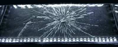 We’re used to radiation being invisible. With a Geiger counter, it gets turned into audible clicks. What you see below, though, is radiation’s effects made visible in a cloud chamber. In the center hangs a chunk of radioactive uranium, spitting out alpha