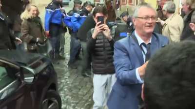an old man cracks an egg on french politician Eric Zemmour’s Head