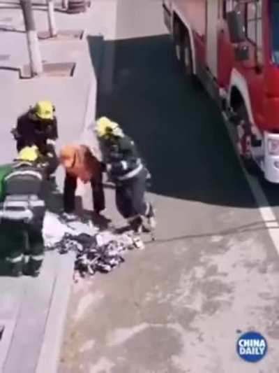 Firefighters stop to help out a dude cleaning.