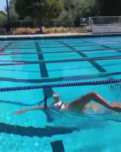 Olympic Gold Medalist, Katie Ledecky, swims with a glass of chocolate milk on her head