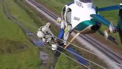 Helicopter transferring linemen to power lines.