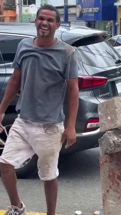 Dominican man puts 2 blocks and 1 big stone on top of a glass bottle