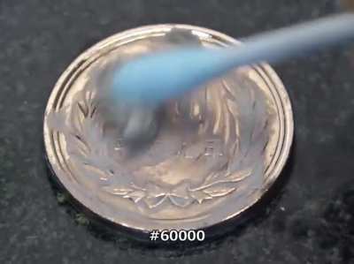 Leaning and polishing a coin