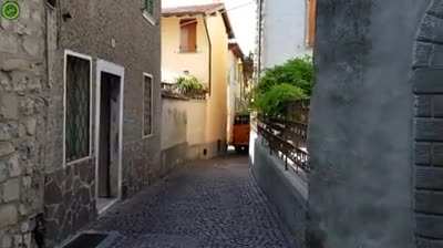 A bus driver driving through a narrow town in Northern Italy
