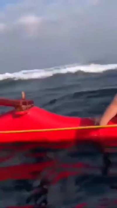 Whale jumps out of water near a canoe