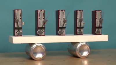 Metronomes started randomly synchronize after a short period of time as they influence each other through the side-to-side motion of their shared base, a mechanical realization of the mathematical "Kuramoto model". Source: UCLA Physics &amp; Astronomy