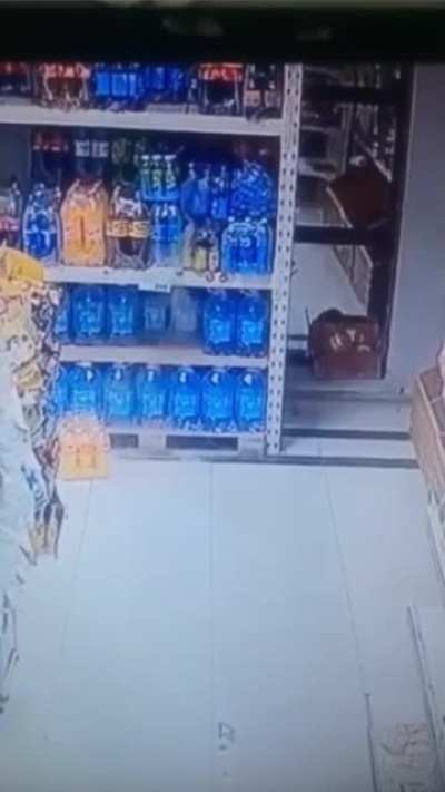 Bottle falls then lands back on shelf