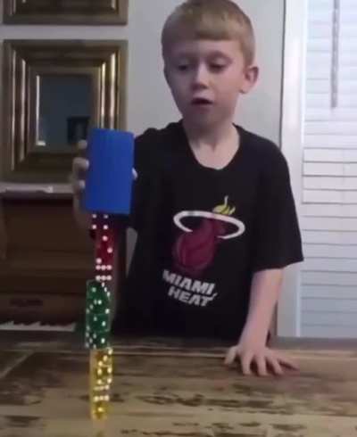 Kid stacks dice using a cup