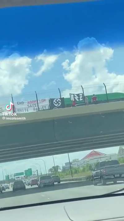 Neo-nazis hold up signs on the overpass to Disney park in Florida.