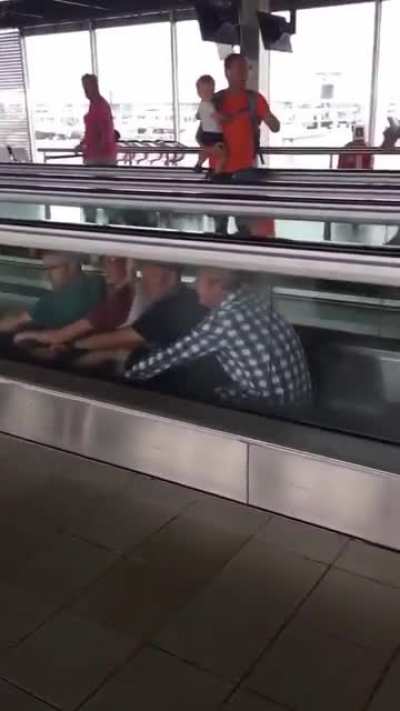 Four men having a little fun at an airport.?