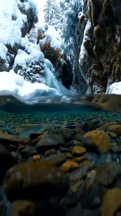 ? Snow falling on crystal clear Alaskan glacial meltwater captured by photographer John Derting