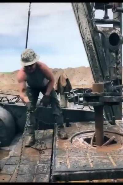 Roughnecks "throwing the chain" on an oil rig - old-school method of tightening drill pipe