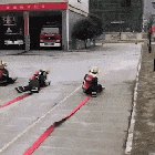 Teaching kids how to handle fire hoses. Watch as the one of the left starts to take off.
