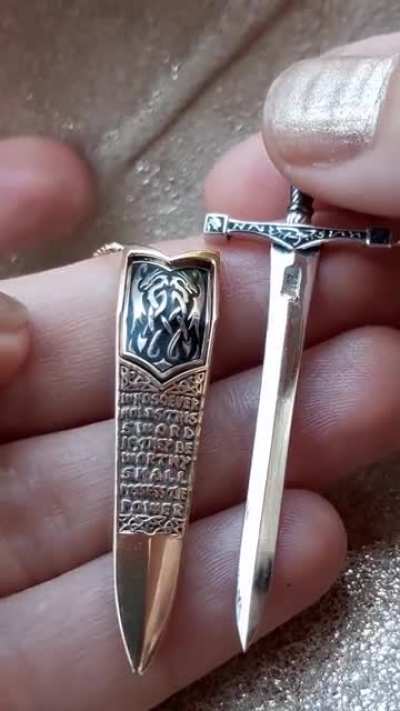 This tiny handmade Excalibur sword necklace that can be unsheathed by a hidden button