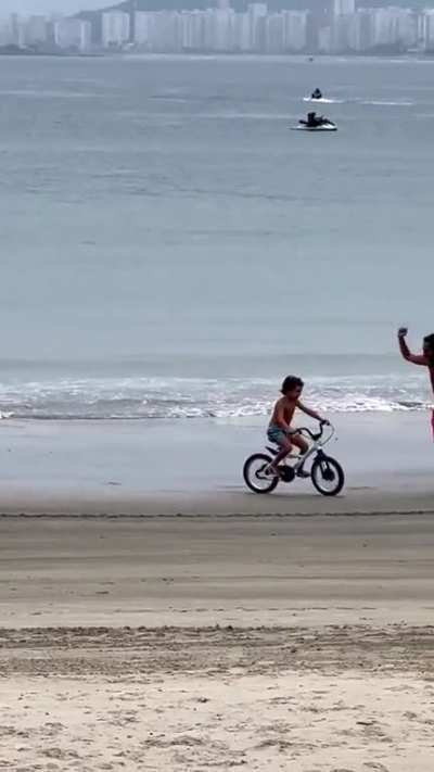 This kid learning to ride a bike with his father